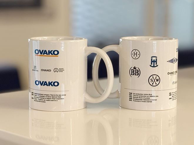 Ovako mugs with the history of logos on a table